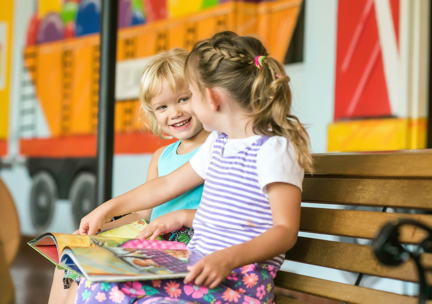 Two Girls looking at a book and smiling