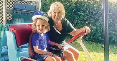 child in helmet on golf cart